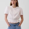 Blusa corta con peplum y cierre frontal de botones