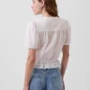 Blusa corta con peplum y cierre frontal de botones