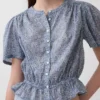 Blusa corta con peplum y cierre frontal de botones