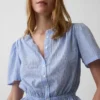 Blusa corta con peplum y cierre frontal de botones