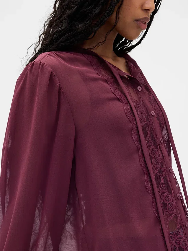 Blusa transparente con inserciones de encaje reciclado y cuello con lazo